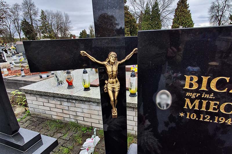 Metalowa figura Chrystusa na granitowym krzyżu